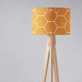 Modern tripod floor lamp with butterscotch yellow geometric hexagons lamp shade and light wooden legs for table lamp use