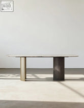 Minimalist cameron marble dining table with light marble top and contrasting brass and dark wood cylindrical legs