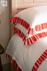 White pillowcases from candy cane collection with vibrant red ruffled trim and classic striped edges for duvet cover