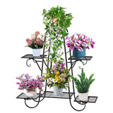 Black wrought iron metal plant stand with ornate scrollwork and four tiers holding white and blue ceramic pots
