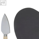Cheese knife with sleek metallic blade and light wooden handle on a carter heart slate cheese board