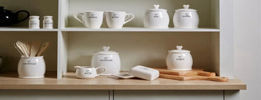 White dolomite butter dish with heart shaped lids and black printed labels in a charming kitchenware set