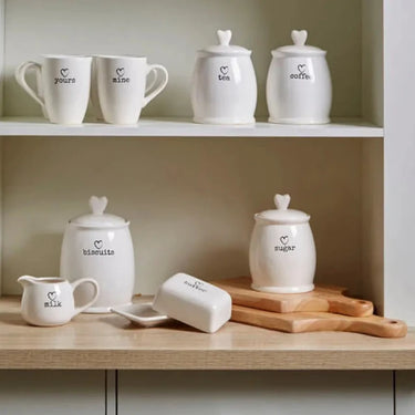 White dolomite sugar canister set with heart-shaped lids and black printed labels for charming kitchen storage