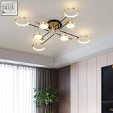 Modern flush mount chandelier with gold circular rings and black arms perfect for low ceiling lighting