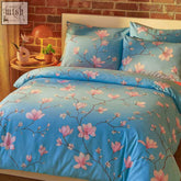 Blue satin duvet cover with pink magnolia blossoms and branches from cherry blossom bedding set flat bed sheet look