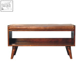 Chestnut bench with brown leather seatpad features a brown leather seat and wooden tapered legs with a lower shelf