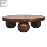 Round wooden coffee table with rich chestnut finish and three dark brown spherical legs from chestnut central ball collection