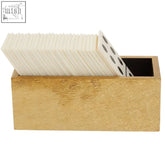 Gold-finished card holder with textured surface holding white cards with black dots in churchill games white domino set with white dominoes