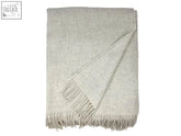 A soft light gray clova merino lambswool throw blanket with textured fabric and matching fringed edges perfect for cozy nights