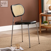 Coer rattan dining chair with black leather seat and woven rattan backrest on sleek chrome legs