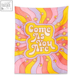 A vibrant retro tapestry with come as you are in bold yellow and white on a swirling pink orange purple background
