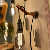 A warm glowing edison bulb mounted on a copper wall light with industrial pipe arm perfect for hallway lighting