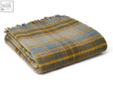 Folded cottage check pure new wool throw blanket in mustard with a soft textured plaid pattern in muted greens and yellows