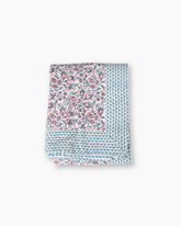 Folded light blue and pink floral cotton quilt with scalloped border from cranberry pink hand blocked tablecloth collection