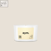 A white cylindrical mini candle in a minimalist container with a beige label from eym called the uplifting one