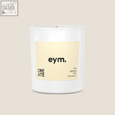 A minimalist white glass standard candle jar with a pale yellow label from eym designed for modern home decor