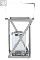 A sleek small silver criss cross lantern with polished chrome frame and clear glass cylinder for modern decor