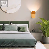 Gold-toned oval daisuke light wall lights with smooth reflective surface casting warm ambient light