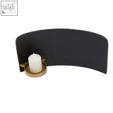 Daito black and gold finish aluminium candle holder with curved design and white pillar candle sits on gold finish base