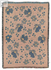 A soft peach deco daisy woven throw blanket with blue gray flowers and textured fringe edges perfect for cozy decor