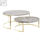 Set of two round white marble cake stands with gray marble tops and sleek gold metal frames for serving cakes