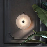 A soft circular marble wall lamp with warm led light and smooth off-white stone texture for modern home decor