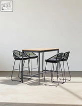 Modern black woven resin bar stools with metal legs and light wood tabletop in dmitry outdoor garden table set