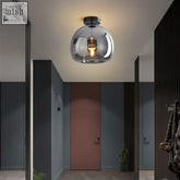 A sleek dome ceiling light with a black gold metallic base and warm glass pendant for bedroom or bathroom ceiling light