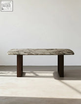 A sleek donovan dining table with a polished gray and white marble top and dark wood legs for modern dining spaces