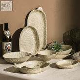 Off-white handcrafted Doshim tableware set of artisanal ceramic plates with textured hammered surfaces and organic shapes