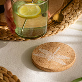 A round natural portuguese cork coaster with a subtle white dragonfly design and heat resistant properties