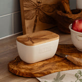 Cream-colored ceramic white butter dish with natural wood lid and engraved dragonfly design
