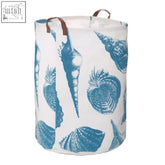 White fabric laundry bag with blue sea shell print and brown leather handles featuring durable laundry bag features