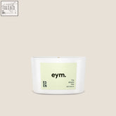 A minimalist white ceramic mini candle jar with a pale green eym label marked 100 percent natural eden mini candle