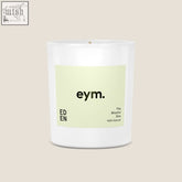 A minimalist white glass standard candle jar with a pale green eym label the blissful one 100 percent natural