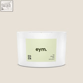 White cylindrical eden three wick candle with pale green eym label the blissful one in black text
