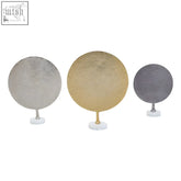 Set of three hammered metal disc sculptures with textured metallic trays and white marble bases for decor