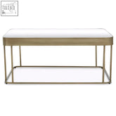 Ella gold coffee table with gold-toned metal frame, white upholstered seat, and matching lower shelf for stylish use