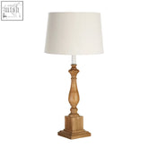 Emely candle table lamp with wooden square base and ornate turned wood base featuring a white cotton mix fabric shade