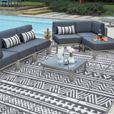 Black and white geometric pattern on enyhom large grey outdoor rug made of durable plastic straw for outdoor patio use