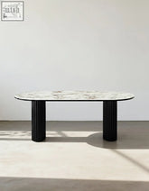 Elegant escobar dining table with oval marble top and sleek black fluted legs perfect for stylish dining areas