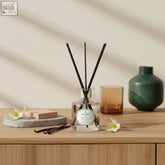 Clear glass reed diffuser with black reeds and parks label featuring fine fragrance ylang ylang natural fragrance oils