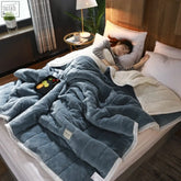 A plush blue and white fleece blanket with soft texture and visible stitching featuring three-layer composite-thickening upgrade lamb wool design