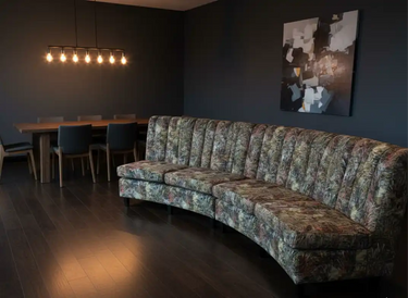 Floral-patterned sofa with dark green and brown hues, plush fabric design.