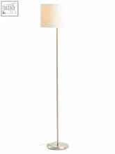 A sleek floor lamp with a tall metallic pole and a cream waffle effect fabric shade forma cream waffle design