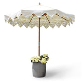 Garden umbrella with removable canopy and hardwood frame featuring white lace trim and beige floral pomegranate eucalyptus pattern
