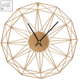 Small gold metal wall clock with gold geometric wireframe and minimalist circular face with black hands