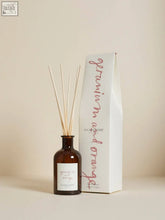 Brown glass geranium and orange diffuser with wooden sticks and plum and ashby label using vegetable oil base