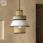 A tiered pendant light called gokna light with woven rattan and textured white fabric shades accented by black trim