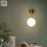 Gold-toned globe wall lamp with spherical frosted glass globe perfect for luxury bedroom and living room lighting
